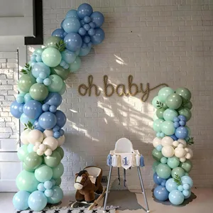 Détail de l'arche de ballons bleu et vert Morandi pour une belle décoration de fête.