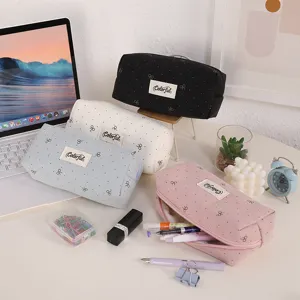 Detailed view of aesthetic canvas pencil cases with cute bow embroidery on a cozy desk.