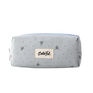 Detail view of the light blue canvas pencil pouch featuring cute bow embroidery and zipper.
