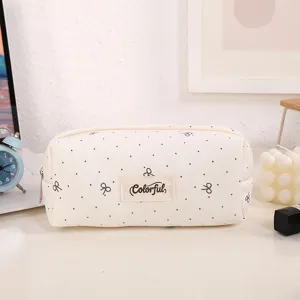 Detailed view of the cute canvas pencil case with bow embroidery and polka dots on a clean desk.