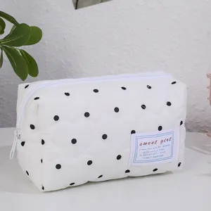 Détail trousse maquillage matelassée cœur, pochette blanche zippée avec joli label tissu.