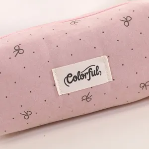 Pink velvet pencil case detail showing cute bow print and Colorful woven label texture.