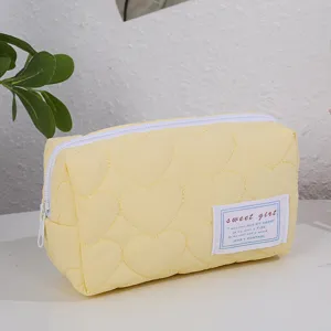 Trousse de maquillage matelassée jaune avec motif cœur, jolie pochette portable pour voyage.