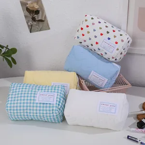 Trousse de maquillage matelassée détail motif cœur et fermeture éclair pratique.