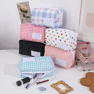 Vue détaillée de trousse de maquillage matelassée, avec motifs de cœurs et fermeture éclair.