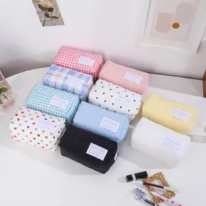 Vue détaillée de trousses de maquillage matelassées multicolores aux motifs mignons.