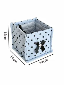 Quilted square storage basket with cute black bows and polka dots for desk organization.