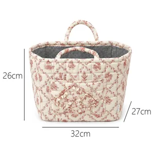 French style quilted storage basket with red floral print, double handles and pocket. Detail view.