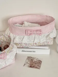 Dettaglio cestino portaoggetti in pizzo floreale rosa, organizer scrivania con fiocco.