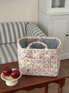 French style quilted storage basket with cute floral print, handles and pocket for home organization.