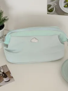 Hellgrüne Kosmetiktasche mit großer Öffnung und Metall-Hauslogo, ideal für Make-up-Aufbewahrung.