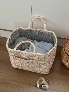 Detailed view of French vintage floral quilted storage basket with blue gingham lining.