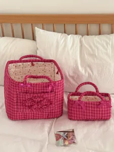 Pink quilted storage basket set with cute bows and floral lining for bedroom organization.