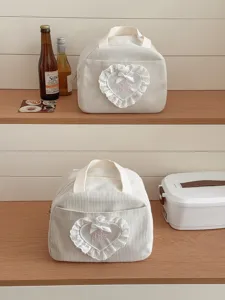 Detailansicht der niedlichen Kord-Lunchtasche mit elegantem Spitzen-Herz-Aufnäher und Schleife.