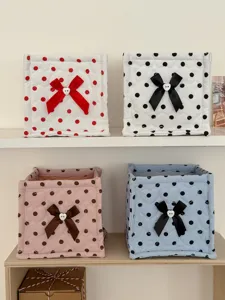 Quilted polka dot fabric storage basket with cute bow, perfect for desk and dorm organization.