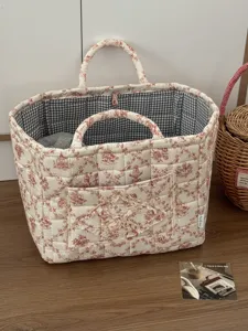 Chic French vintage floral quilted fabric storage basket with dual handles and front pocket.
