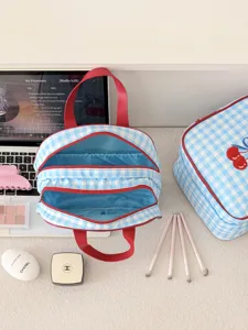 Blue and white checkered makeup bag with red trim, multi-compartment travel organizer.