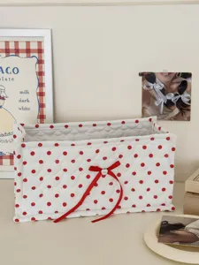 White quilted storage box with red polka dots and bow, detail view of fabric desk organizer.