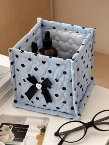 Blue quilted storage basket detail, cute polka dot fabric design with black bow for desk organization