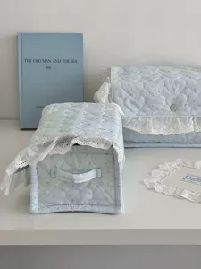 Light blue quilted storage box with delicate lace trim, perfect for bedroom organization.