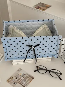 Blue polka dot quilted storage box with bow detail on desktop for daily organization