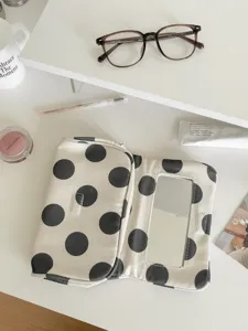 Detailed view of the chic black and white polka dot canvas makeup bag with built-in mirror.