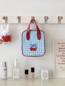 Blue gingham cherry cosmetic bag with red handles, portable travel makeup storage pouch.