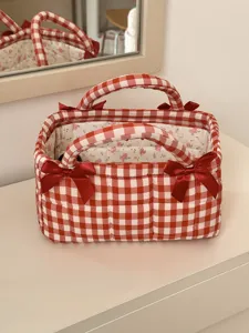 Detail view of red white plaid quilted storage basket with sweet bow knots and floral interior.