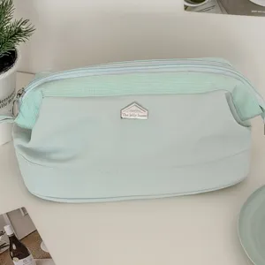Große hellgrüne Kosmetiktasche mit Metalllogo, stilvolles Etui mit Reißverschluss.