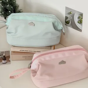 Kosmetiktasche mit grossem Fassungsvermoegen und Metalllogo fuer Reisen und Alltag.