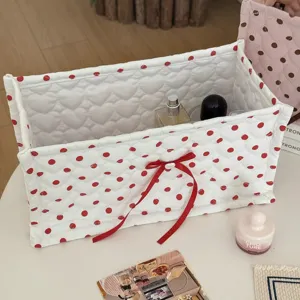Cute quilted rectangular storage basket with red polka dots and bow for desktop organization.