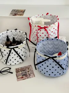 Quilted polka dot cylindrical storage basket with cute bow, perfect desktop organizer bin.