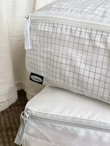 Grid pattern detail of portable storage bag with smooth zipper and durable fabric.