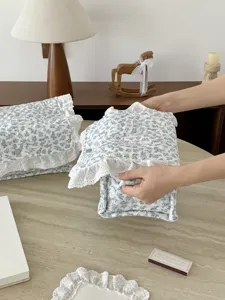 Detailaufnahme des blauen Blumenstoff Aufbewahrungskorbs mit weißer Spitze im Zimmer.