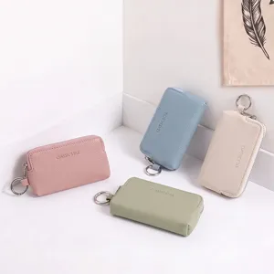 Porte-monnaie et étui à clés compact en cuir avec motif litchi et fermeture éclair en métal.