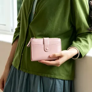 Close-up detail of a pink folding wallet, compact size with card slots and zipper design.
