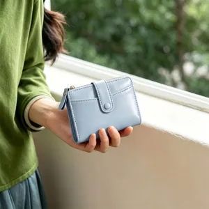 Detailed view of the light blue folding wallet showcasing multi-card slots and zipper pocket.