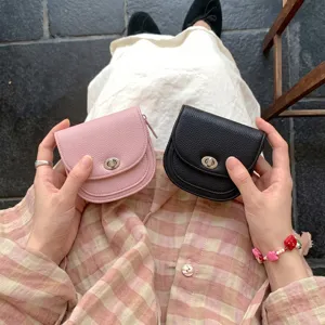 Close-up detail shot of the compact leather coin purse featuring a stylish turn-lock and zipper.