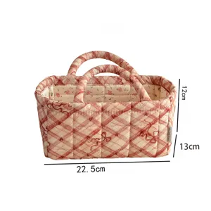 Quilted fabric storage basket with pink plaid and bow design for desktop sundries organization.