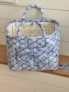 Detaillierte Nahaufnahme des gesteppten Aufbewahrungskorbs mit blauem Karo- und Blumenmuster.