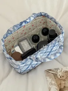 Quilted fabric storage basket with blue bow pattern, ideal for desktop and makeup organization.