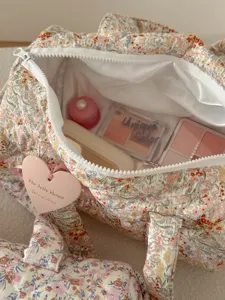 Dettaglio interno della borsa da viaggio trapuntata floreale con ampio spazio di archiviazione.
