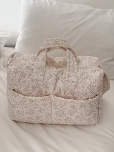 Close-up detail of the quilted floral travel bag, showcasing soft fabric and cute pattern.