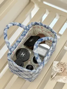Detailed view of quilted storage basket with blue plaid design and floral inner lining.
