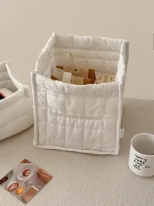 Gedetailleerd overzicht van een witte, gewatteerde opbergmand voor bureau en knusse inrichting.