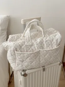 Detail shot of cozy floral quilted travel bag, large capacity aesthetic commuter tote.