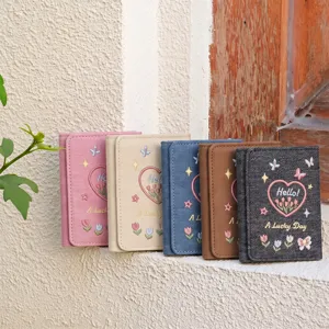 Detailed shot of multi-color tri-fold short wallets with cute floral embroidery and lovely text.