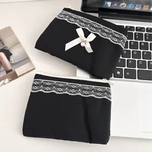 Bolsa de maquillaje acolchada negra con encaje blanco y un lindo lazo de perlas.