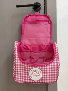 Detail van roze ruitjes toilettas, met interne gaasvakken en een handig ophangbaar ontwerp.