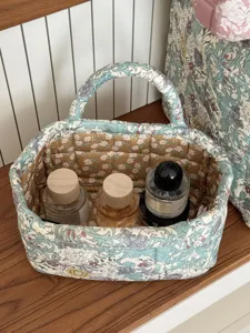 Quilted fabric storage basket with floral pattern, ideal for desktop organization and decor.